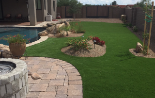 Backyard in Oro Valley with artificial turf, pavers, and desert-friendly landscaping