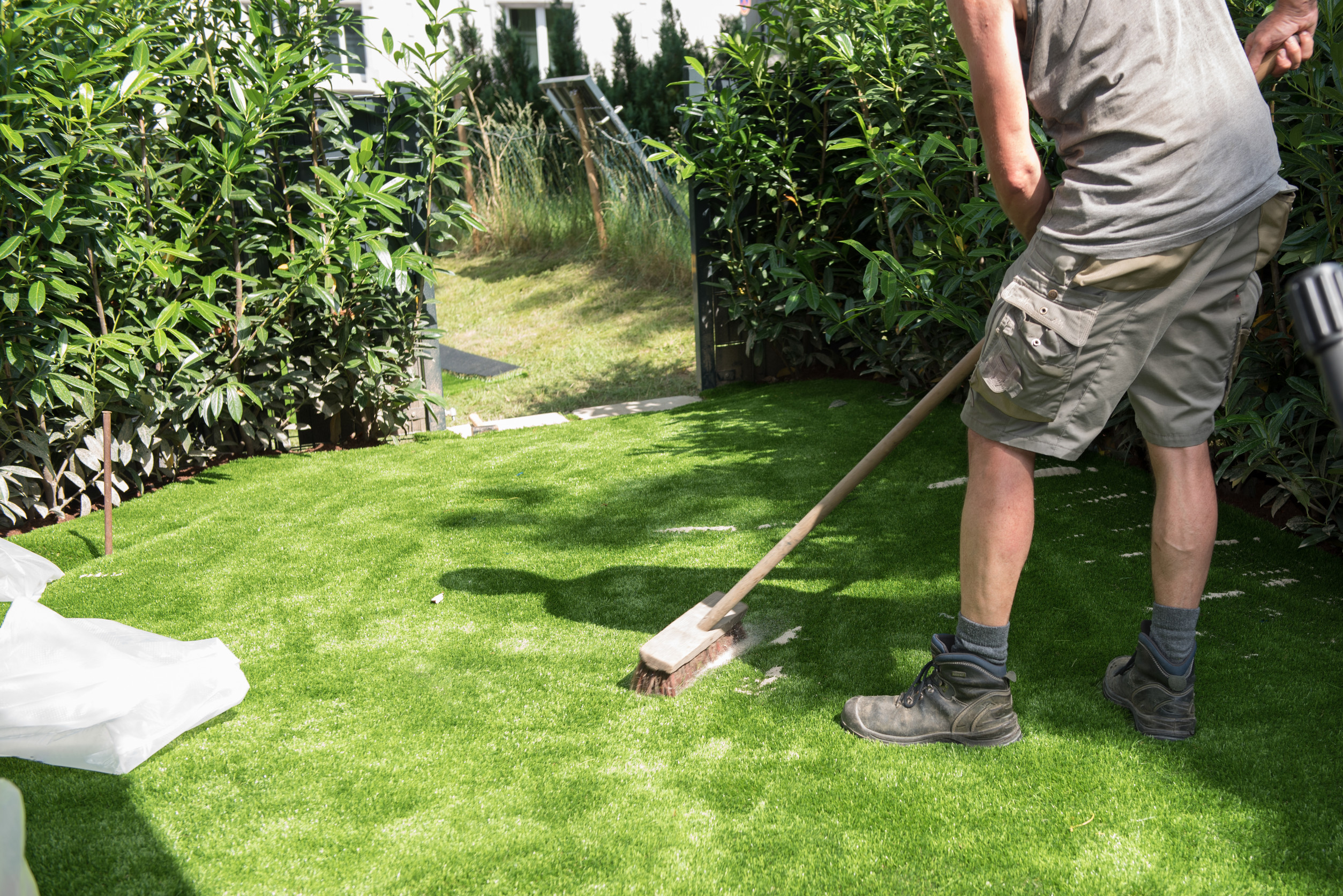 homeowner brushing artificial turf in Tucson backyard